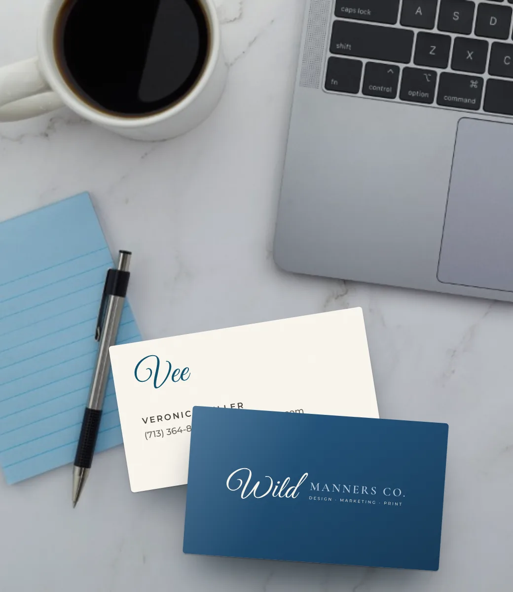 Wild Manners Co. business cards on a desk next to a laptop